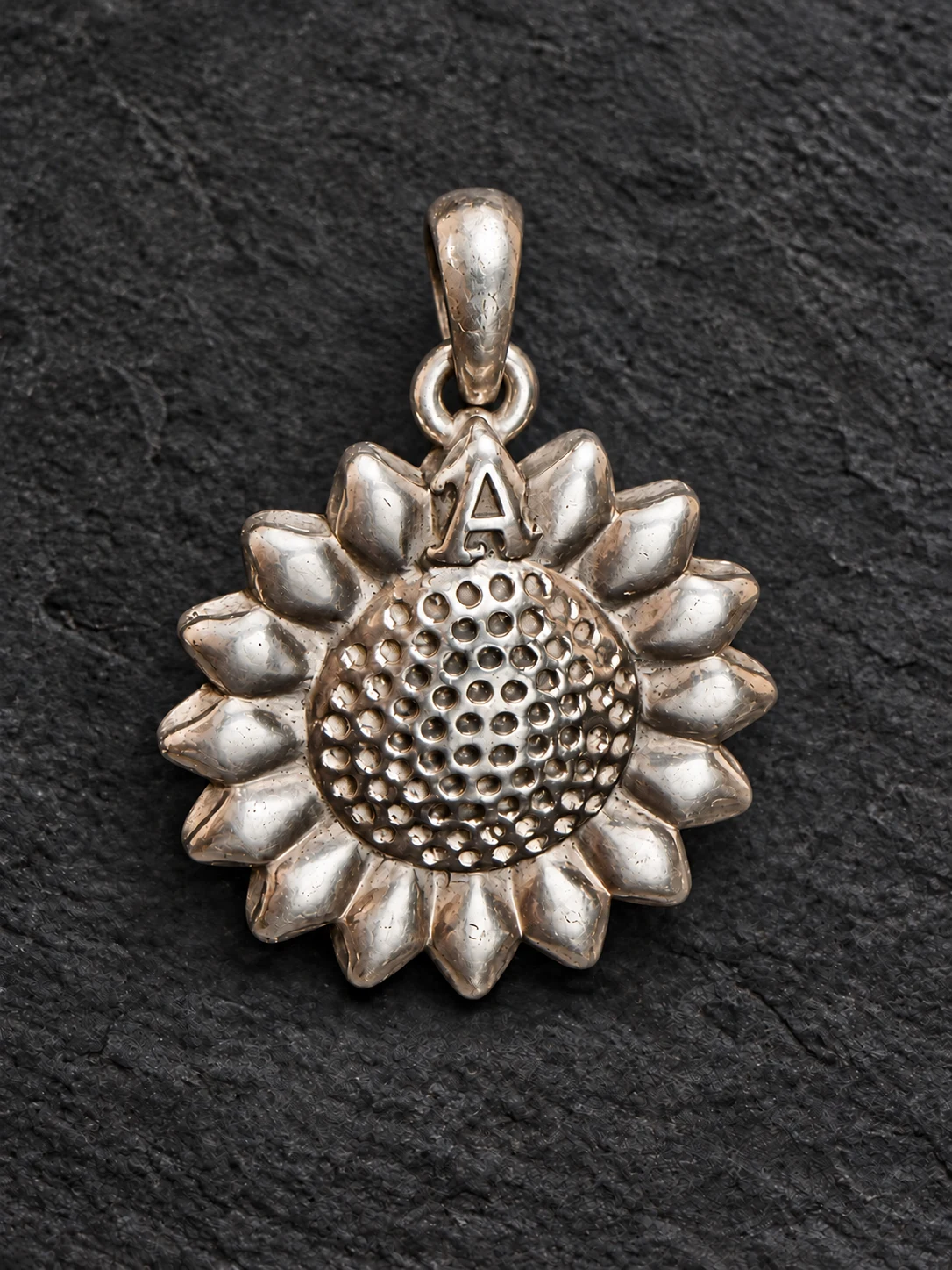 Commissioned sunflower memorial pendant with the initial A, presented on charcoal stone