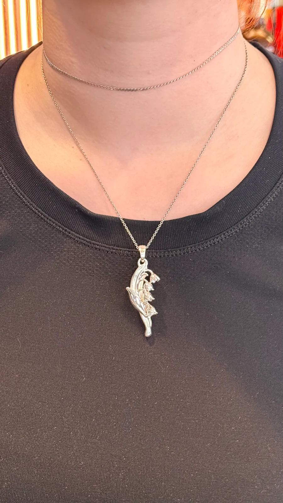 Lily of the Valley pendant worn on a chain