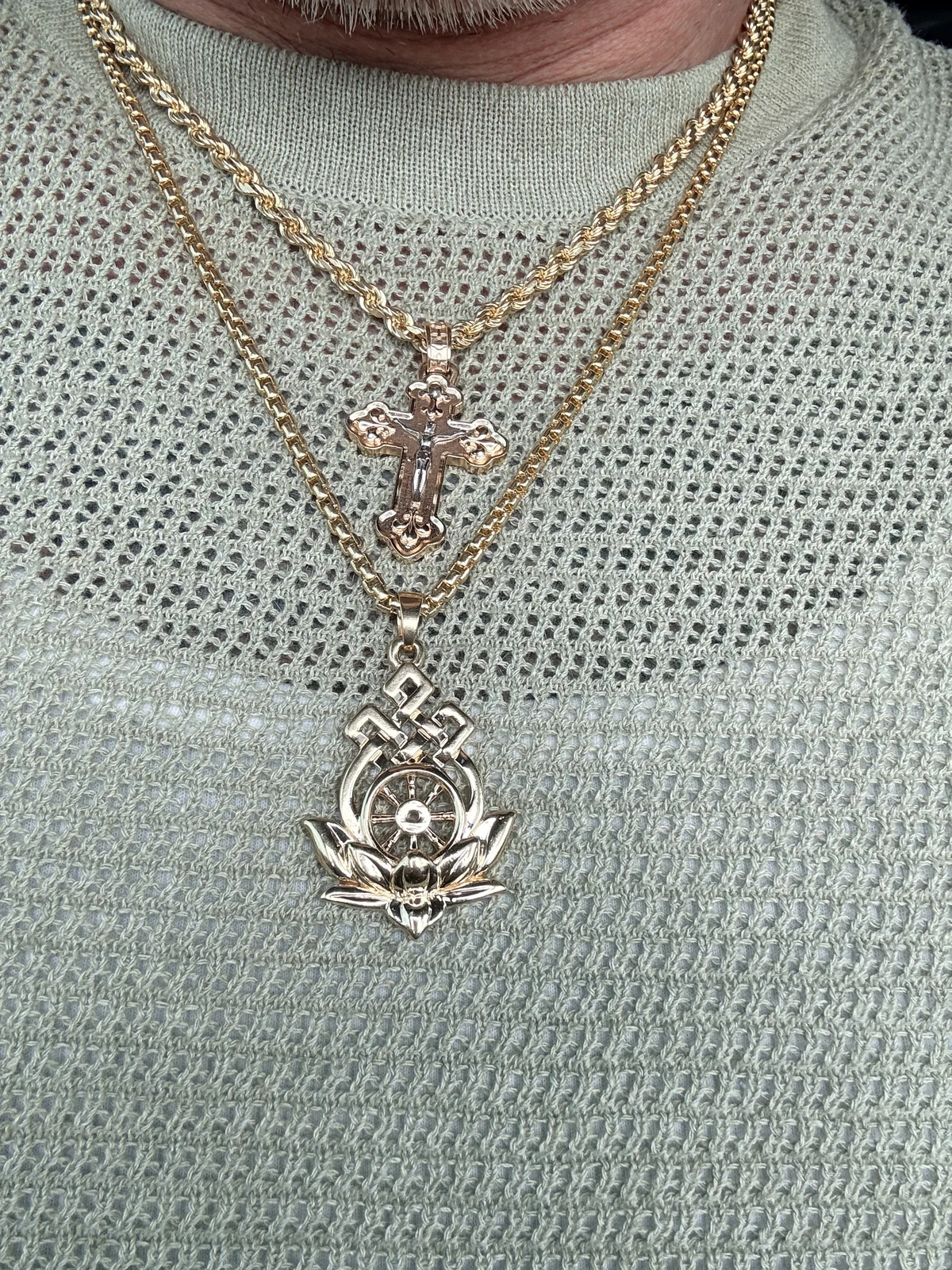 Buddhist lotus pendant worn on a chain below an Orthodox Cross